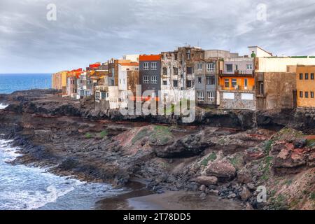 Une rangée de maisons est perchée le long du bord d'une côte de glissement de terrain océanique. Maisons colorées sur la côte de Gran Canaria, îles Canaries, Espagne Banque D'Images