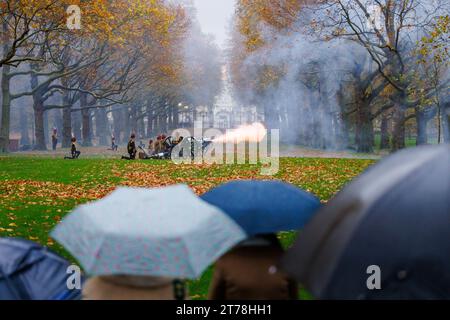 Green Park, Londres, Royaume-Uni. 14 novembre 2023. Les spectateurs regardent sous la pluie battante alors que la troupe royale du roi tire un salut royal de 41 canons à Green Park pour le 75e anniversaire de sa Majesté le roi. Les soldats, les chevaux et les fusils de la troupe royale du cheval de la troupe du roi portent un uniforme complet qui comprend des vestes tressées en or et des chapeaux busby. 71 chevaux tirant six canons de campagne de 13 livres de l'époque de la première Guerre mondiale tiraient des obus d'artillerie à blanc à des intervalles de dix secondes jusqu'à ce que quarante et un coups de feu aient été tirés. Photo par Amanda Rose/Alamy Live News Banque D'Images