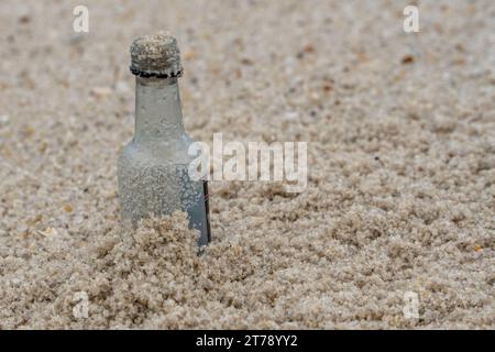 Bouteille d'alcool à usage unique lavée sur la plage Banque D'Images