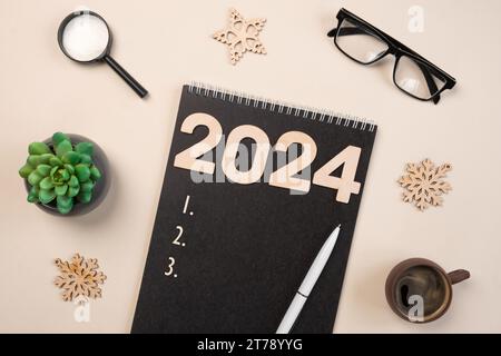 Objectifs de la nouvelle année 2024. Liste des tâches. Carnet vide au bureau avec décoration des fêtes. Vue de dessus. Création d'un plan, résolution. Nouvelle vie, Start Up, Beginning Banque D'Images