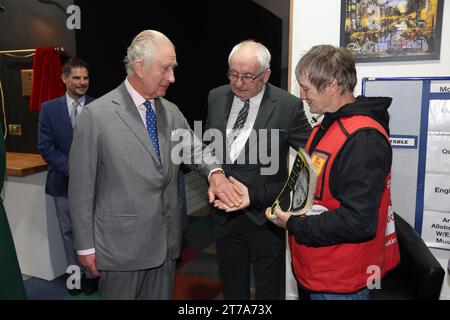 Le roi Charles III, achète une copie de The Big issue au vendeur Kelvin avec Lord John Bird, le fondateur de The Big issue, au lancement du Coronation Food Project, qui vise à combler le fossé entre le gaspillage alimentaire et les besoins alimentaires dans les quatre nations du Royaume-Uni, au centre de distribution de surplus de nourriture de South Oxfordshire Food and Education Alliance (SOFEA), à Didcot, Oxfordshire. Date de la photo : mardi 14 novembre 2023. Banque D'Images