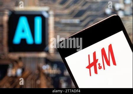 Dans cette illustration photo, le logo de la multinationale suédoise de design de vêtements Hennes & Mauritz, H&M, est affiché sur un smartphone avec une puce d'intelligence artificielle (IA) et un symbole en arrière-plan. Banque D'Images