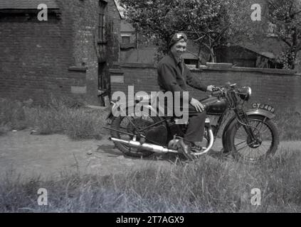 Années 1950 historique, un jeune homme avec chapeau et lunettes de visage assis sur une moto Sunbeam de l'époque, Oldham, Manchester, Angleterre, Royaume-Uni. Sunbeam cycles, une marque britannique de bicyclettes produite pour la première fois en 1887 par John Marston, qui en 1912 a commencé à fabriquer des motos à Woverhampton, qui a continué jusqu'en 1937, jusqu'à ce que la marque soit vendue à Associated Motor cycles (AMC). En 1943, AMC a vendu le nom Sunbeam à la plus grande société BSA, qui a continué la production jusqu'en 1956, lorsque les faibles ventes ont vu la fin de la production. Banque D'Images