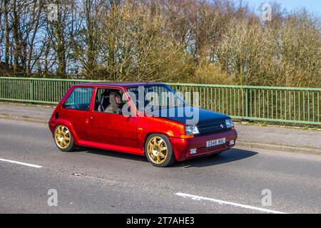 Années 1986 80 années 80 Custom RENAULT 5 GT Turbo 1397 cc rouge essence à hayon ; traversant le pont d'autoroute dans le Grand Manchester, Royaume-Uni Banque D'Images