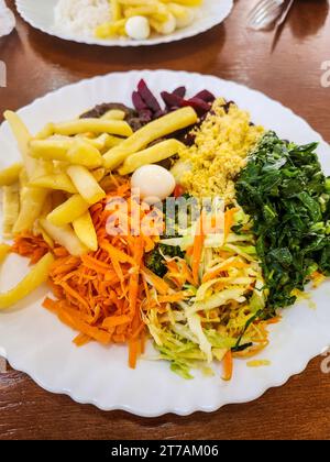 Assiette de nourriture avec frites, chou, carottes, betteraves, oeufs de caille, farofa, sur une table à Rio de Janeiro. Banque D'Images