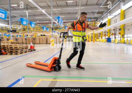 Erding, Allemagne. 14 novembre 2023. Un employé d'Amazon explique les processus dans l'établissement lors de l'ouverture officielle du centre de tri Amazon à Erding. Crédit : Peter Kneffel/dpa/Alamy Live News Banque D'Images