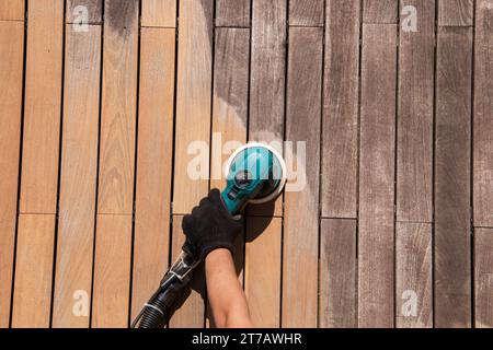 Texture des panneaux de terrasse en bois IPE avant et après le ponçage ponceuse électrique orbitale gris argenté patine nettoyé le bois dur Banque D'Images