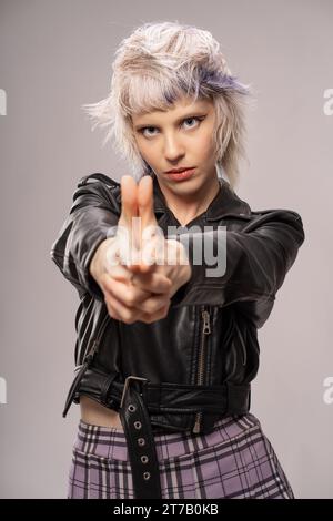 Jeune adulte présentant un style de mode punk avant-gardiste avec une pose confiante, exsudant une attitude rebelle et avant-gardiste. Banque D'Images