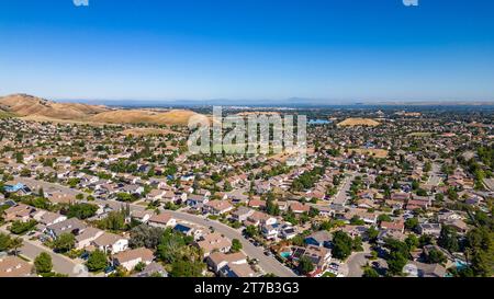 Images aériennes au-dessus d'une communauté à Antioch, Californie avec des maisons avec des collines luxuriantes solaires et vertes après la pluie Banque D'Images