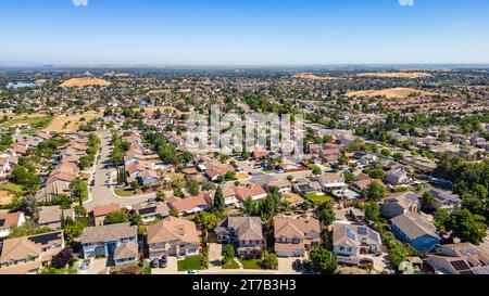 Images aériennes au-dessus d'une communauté à Antioch, Californie avec des maisons avec des collines luxuriantes solaires et vertes après la pluie Banque D'Images
