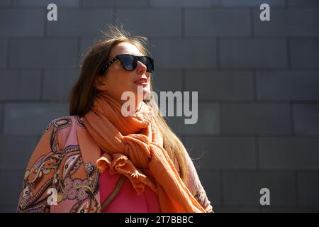 Portrait de la femme d'affaires mi-30 avec les cheveux bruns avec des lunettes de soleil noires Banque D'Images