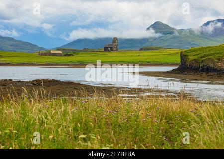 Les nuages bas tombent au-dessus de St. Edwards église sur Sanday, île de Canna, petites îles, Écosse avec grange abandonnée et l'île montagneuse de Rum à l'arrière Banque D'Images