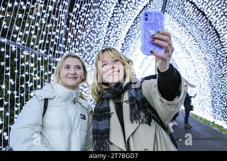 Londres, Royaume-Uni. 14 novembre 2023. Deux visiteurs prennent des selfies dans l'installation lumineuse toujours populaire de la cathédrale de Noël, inspirée par une fenêtre d'église voûtée. Le célèbre Noël à Kew revient à Kew Gardens dans l'ouest de Londres. Le parcours festif original à travers le paysage après la tombée de la nuit de Kew revient pour sa onzième année avec une foule de favoris saisonniers ainsi que plusieurs nouvelles installations lumineuses. Crédit : Imageplotter/Alamy Live News Banque D'Images