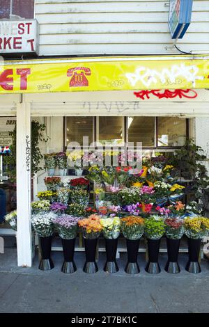 Présentation de bouquet de fleurs sur le trottoir devant le magasin général. Vancouver, C.-B., Canada. Banque D'Images