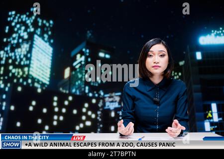 Newscaster avertit les gens de l'animal sauvage qui s'est échappé du zoo local, effrayant la population et provoquant la panique dans la ville. Femme asiatique en direct sur spectacle de nuit, évasion de la faune. Banque D'Images