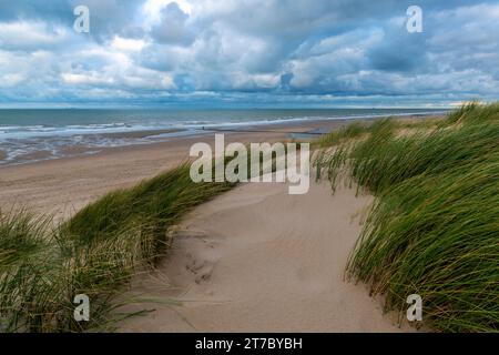 Dunes de sable et plage de la mer du Nord avec ciel pluvieux dramatique, Flandre occidentale, Belgique. Banque D'Images