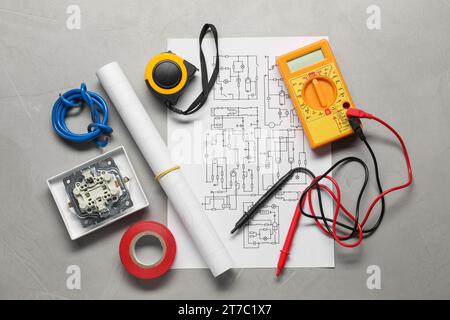 Schéma de câblage, fils et multimètre numérique sur table gris clair, à plat Banque D'Images