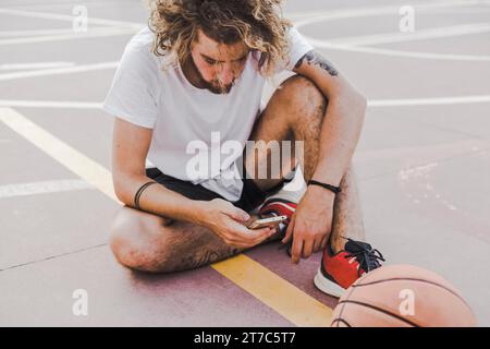 Terrain de basket-ball utilisant un téléphone portable Banque D'Images