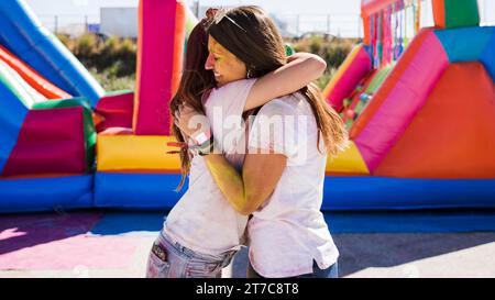 Des jeunes femmes s'embrassant les unes les autres célébrant le festival Holi Banque D'Images