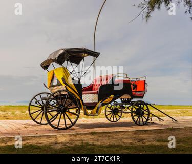Beau parking trishaw sur le pavé, en attendant que les visiteurs montent et profitent du magnifique front de mer à Mersing, Johor, Malaisie. Banque D'Images