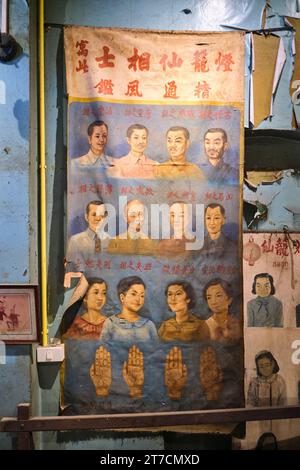 Une vieille affiche traditionnelle peinte à la main heureux portraits et mains. Au Charoen Chai Community Museum à Chinatown, Bangkok, Thaïlande. Banque D'Images