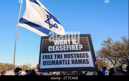 Washington, DC., États-Unis, 14 mars 2023 panneau Held Aloft 'vous voulez un cessez-le-feu?' Avec drapeau israélien volant derrière Banque D'Images