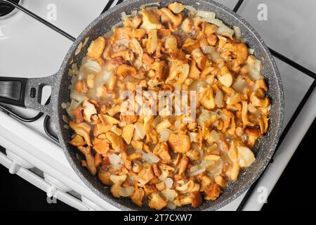 Vue en gros plan des champignons chanterelles frits avec oignon dans une poêle Banque D'Images