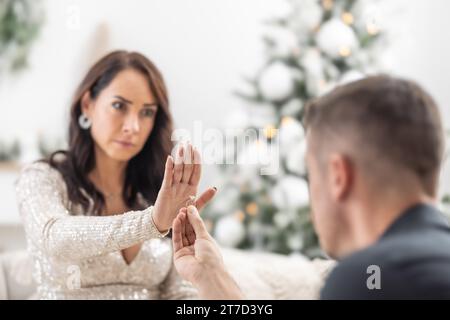 Femme refuse une proposition à un homme qui éternue devant elle avec une bague à la main pendant Noël. Banque D'Images