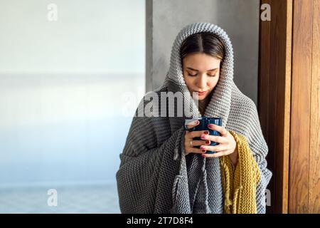 Femme en train de geler souffrant du rhume ou de la grippe ou ayant des difficultés avec le chauffage central Banque D'Images