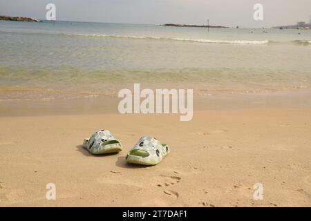 20 juin 2023 Netanya Israël, sable de plage et eau de mer, pantoufles Banque D'Images