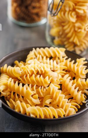 Pâtes fusilli non cuites. Pâtes italiennes non cuites sur l'assiette. Banque D'Images