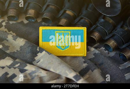 Symbole ukrainien sur la ceinture de mitrailleuse se trouve sur le camouflage militaire pixelisé ukrainien en gros plan Banque D'Images