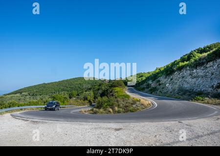 Une voiture négocie un virage en épingle à cheveux sur la route Lakones Makrades Vistonas à Agia Anna, Corfou, Grèce Banque D'Images