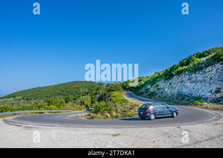 Une voiture négocie un virage en épingle à cheveux sur la route Lakones Makrades Vistonas à Agia Anna, Corfou, Grèce Banque D'Images