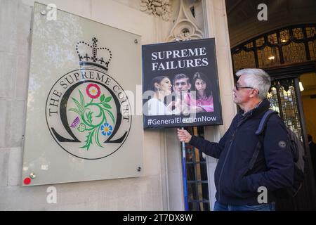 Londres, Royaume-Uni. 15 novembre 2023. Un manifestant tient une pancarte avec les photos du Premier ministre Rishi Sunak et des anciens secrétaires de l'intérieur Priti Patel (à gauche) et Suella Braverman (à droite) devant la Cour suprême. Le gouvernement a perdu un appel devant la Cour suprême pour expulser les migrants illigues vers le Rwanda, pays d’Afrique centrale, après que les juges ont jugé le plan illégal. Le plan d'Ayslum du Rwanda était un élément central des politiques d'immigration du Parti conservateur sous les premiers ministres Boris Johnson, Liz Truss et Rishi Sunak. Crédit : amer ghazzal/Alamy Live News Banque D'Images