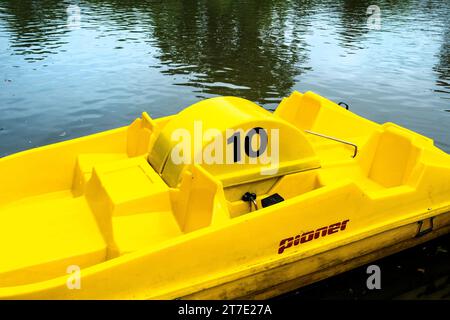 Un bateau Pioner Pedalo jaune vif ; ou location flottant sur Trenance Boating Lake à Newquay en Cornouailles au Royaume-Uni. Banque D'Images