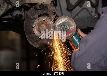 réparation de roues d'automobiles utilisant une meuleuse d'angle dans le service automobile Banque D'Images