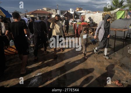 Khan Yunis, Territoires palestiniens. 15 novembre 2023. Les Palestiniens déplacés se promènent autour des abris temporaires dans lesquels ils vivent après avoir fui le nord de la bande de Gaza par crainte des bombardements israéliens. Crédit : Mohammed Talatene/dpa/Alamy Live News Banque D'Images