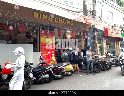 Lors du festival de la mi-automne, les gens choisissent souvent d'acheter des gâteaux traditionnels dans la boutique bien connue. Boutique bien connue sur la rue Thuy Khue. Tiệm bánh Bảo Phương Banque D'Images