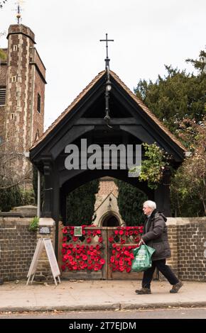 Coquelicots rouges brillants tricotés à la main sur le lychgate de l'église St Mary, Barnes, Londres, SW13, Angleterre, ROYAUME-UNI Banque D'Images