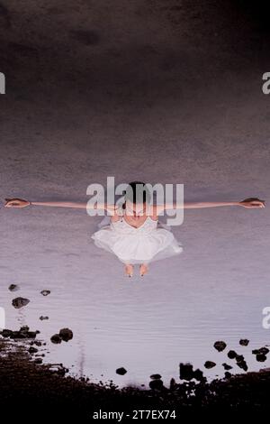 Une femme brune en costume blanc profite d'un moment de détente en profitant des thérapies à l'eau de mer Banque D'Images