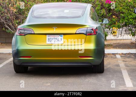 Travail de peinture flip satiné vert et jaune de vue arrière sur la voiture Tesla 3 Banque D'Images