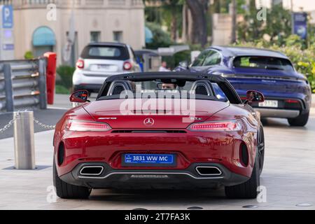 Monte Carlo, Monaco - Bourgogne Mercedes-AMG GT C Roadster conduite sur la place du Casino. Banque D'Images