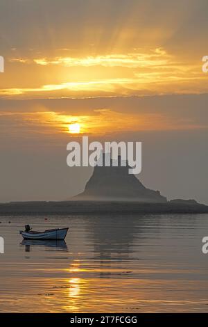 Lever de soleil en été sur le château de Lindisfarne sur l'île Sainte de Lindisfarne dans le Northumberland vu du port Banque D'Images