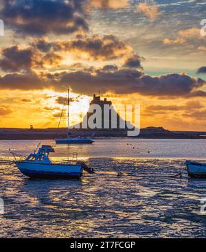 Lever de soleil en été sur le château de Lindisfarne sur l'île Sainte de Lindisfarne dans le Northumberland vu du port Banque D'Images