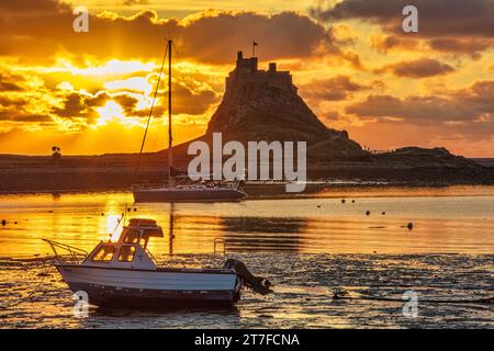 Lever de soleil en été sur le château de Lindisfarne sur l'île Sainte de Lindisfarne dans le Northumberland vu du port Banque D'Images