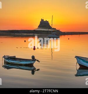 Lever de soleil en été sur le château de Lindisfarne sur l'île Sainte de Lindisfarne dans le Northumberland vu du port Banque D'Images