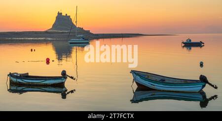 Lever de soleil en été sur le château de Lindisfarne sur l'île Sainte de Lindisfarne dans le Northumberland vu du port Banque D'Images