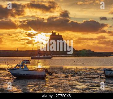 Lever de soleil en été sur le château de Lindisfarne sur l'île Sainte de Lindisfarne dans le Northumberland vu du port Banque D'Images