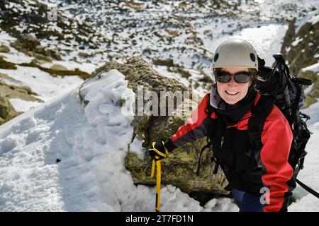 Mountaineer prenant selfie sur terrain enneigé pendant la randonnée Banque D'Images